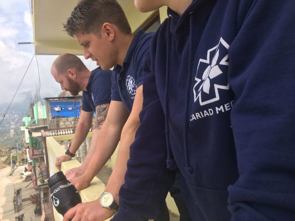 Row of three men in navy uniforms with the Cariad Medic logo.